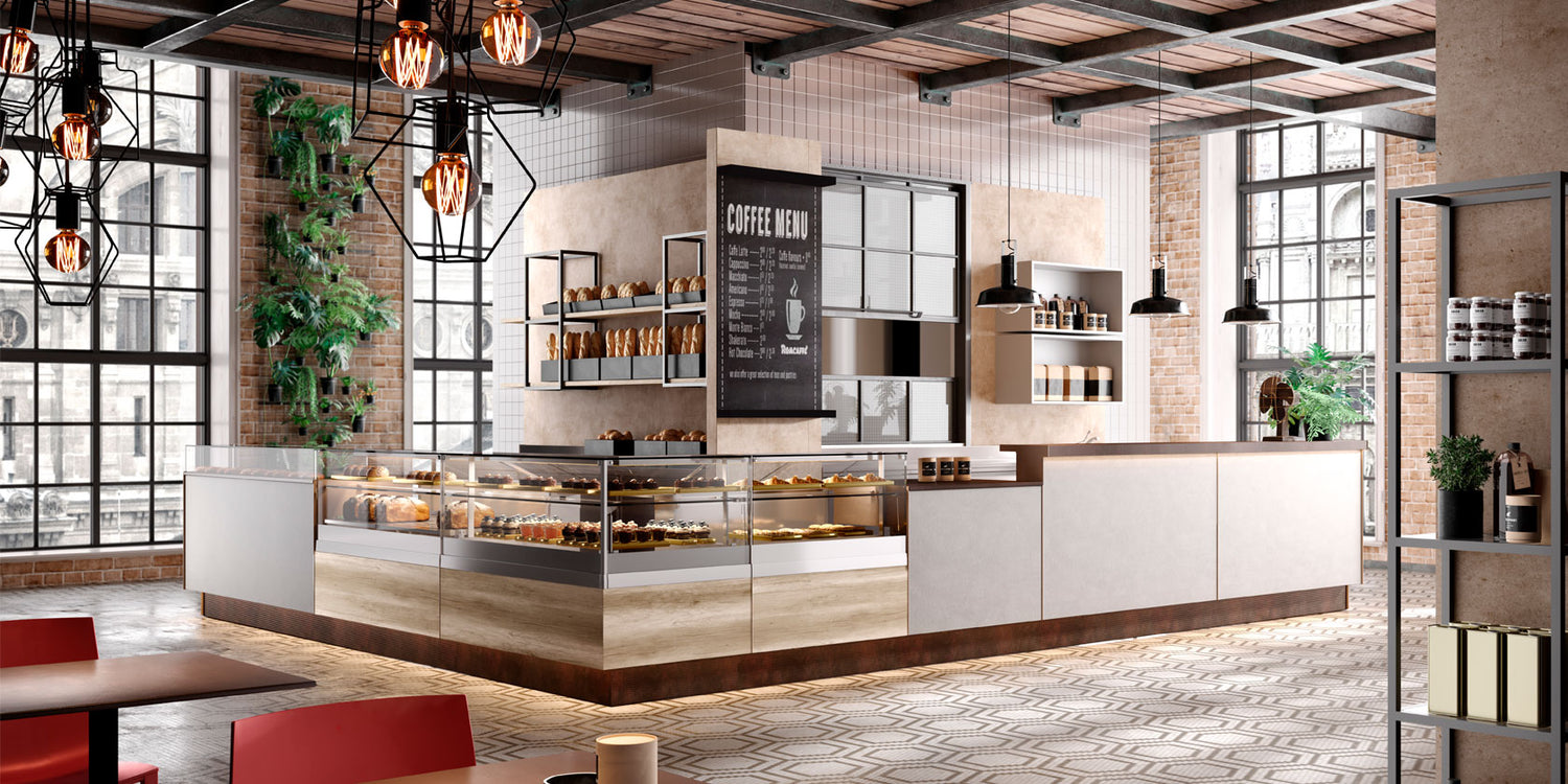 Esempio di un arredamento locale Bakery, dove si vede centro foto un bancone modulare ad L composto da sette moduli con 3 spazi a vetrina espositiva sull'angolo della L. e 4 spazi utilizzati come banco appoggio. Attorno si not l'arredo con sedie e tavoli, travatura a vista e scafali espositivi in un contesto di locale molto luminoso determinato da grandi finestre