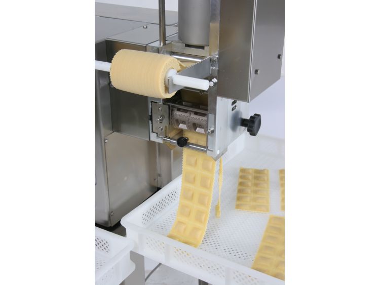 Peimo piano al gruppo ravioli in produzione con sotto una cassa di plastica per la raccolta pasta